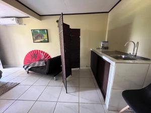 una cocina con fregadero y un sofá en una habitación en Hotel Azul Coral, en Cahuita
