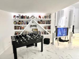Una sala de estar con una mesa y un televisor. en ESPECTACULAR Hogar en la playa MARBELLA, en Marbella