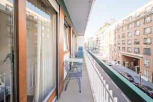 a balcony with a chair and a view of a street at Appartement Glaciere in Paris