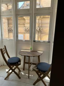 a table and two chairs in front of a window at 15 Main Gate in Birgu