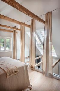 una camera da letto con un grande letto con tende di Hus 42 a Fårup