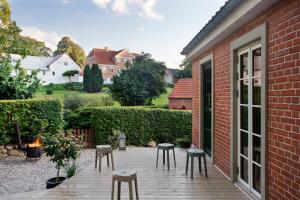 eine Terrasse mit Hockern neben einem Backsteingebäude in der Unterkunft Hus 42 in Fårup