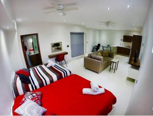 a living room with a red bed and a couch at En el Centro 3 Hermoso Loft Familiar AC WiFi 300 mbps in Aguascalientes