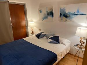 バルセロナにあるModernismo Paseo de Graciaのベッドルーム1室(青と白のベッド、ランプ2つ付)