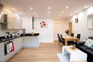 een keuken en een woonkamer met een bank en een tafel bij Oxford CityCenterTrainStation two bedroomApartment in Oxford