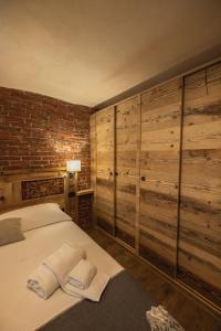 ein Schlafzimmer mit Holzwänden und ein Bett mit Handtüchern in der Unterkunft La Casa del cuore in Fenis