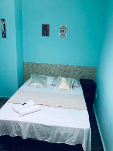 a blue room with a bed with two towels on it at Pousada Biribiri in Salvador