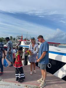 a man and a woman standing next to a boat at Aanirustayinn in Hoarafushi