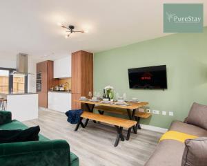 a living room with a table and a kitchen at Perfect for Business Stays in Manchester - 5 Bedroom House By PureStay Short Lets & Serviced Accommodation in Manchester