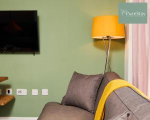 a living room with a couch and a lamp at Perfect for Business Stays in Manchester - 5 Bedroom House By PureStay Short Lets & Serviced Accommodation in Manchester
