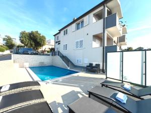 a swimming pool in front of a building at Apartments Katic in Ražanj
