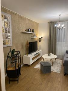 a living room with a tv and a couch and a table at Mountain View Apartment in Poprad