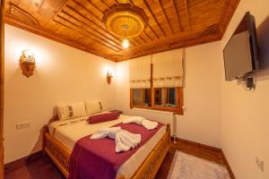 番紅花城的住宿－Manzara Konak Otel，一间卧室配有一张床和一台平面电视