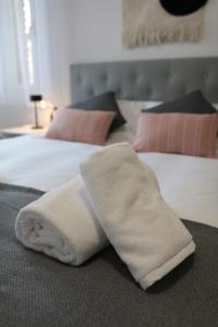 a pile of white towels laying on two beds at Modern Apartament al costat del Parc de la Devesa in Girona