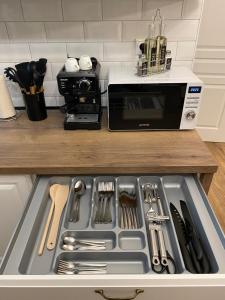 a kitchen counter with a sink with utensils in it at Mountain View Apartment in Poprad