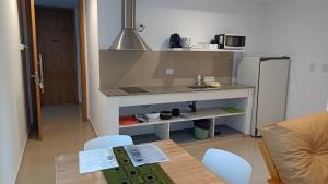 a small kitchen with a table and a refrigerator at Aspromonte Departamentos in La Plata