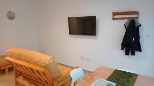 ein Wohnzimmer mit einem Stuhl und einem TV in der Unterkunft Aspromonte Departamentos in La Plata