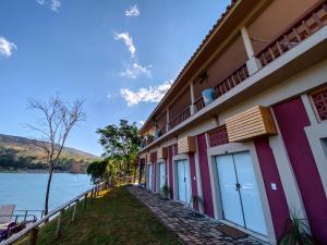 a building next to a body of water at Bica D' Água Boutique Hotel in Capitólio