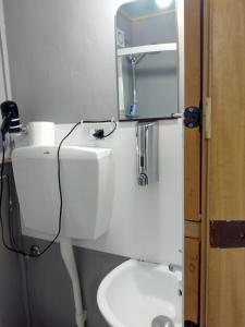 a white bathroom with a sink and a mirror at La Vecchia Locanda in Castelnuovo di Val di Cecina