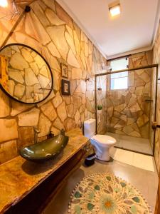 a stone bathroom with a sink and a toilet at Bica D' Água Boutique Hotel in Capitólio