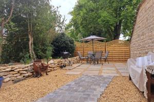 a patio with a table and chairs and a grill at Luxury Victorian Hayloft barn self contained in South Witham