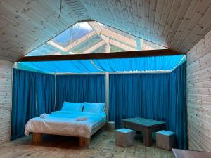 Bett in einem Zimmer mit einem blauen Vorhang in der Unterkunft SkyDoor_ცისკარი in Batumi