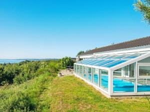una casa de cristal con piscina en un campo en 8 person holiday home in Ebeltoft en Ebeltoft