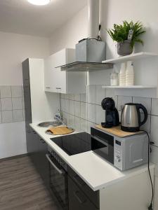 a kitchen with white cabinets and a microwave at R&A in Elsdorf