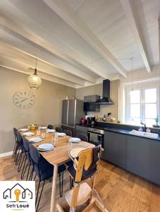 cocina con mesa de madera y sillas en una habitación en Le Refuge Maritime Seh’Loué, en Saint-Quay-Portrieux