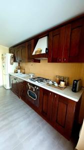 een keuken met houten kasten en een fornuis met oven bij Appartamento B&B La Meta in Fisciano