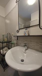 een badkamer met een witte wastafel en een spiegel bij Appartamento B&B La Meta in Fisciano