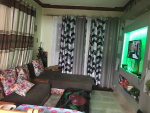 a living room with a couch and some curtains at Christine's Airbnb in Mbale