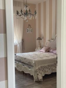 a bedroom with a bed and a chandelier at Annali Casa vacanze - Shabby style nella natura in La Spezia
