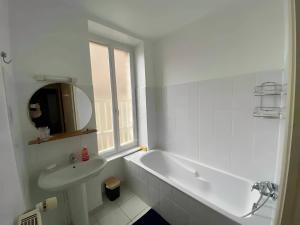 a white bathroom with a tub and a sink at Un moment de Détente au cœur de Vals-les-Bains in Vals-les-Bains