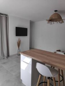 une cuisine avec un comptoir en bois et un plan de travail dans l'établissement Maison indépendante avec terrasse, jardin & parking privé, à Hérépian