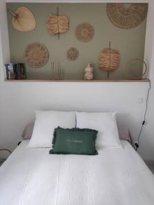 - un lit blanc avec un oreiller vert dans l'établissement Maison indépendante avec terrasse, jardin & parking privé, à Hérépian 8 autres photos