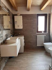 a bathroom with two sinks and a toilet and a window at La Casa Di Emy in Alfedena +19 photos