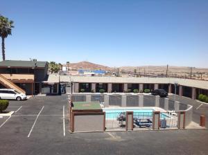 a parking lot with a swimming pool and a building at Budget Inn in Barstow