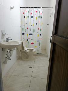 a bathroom with a toilet and a shower curtain at Quédate con Keny & Vivi in Ibagué
