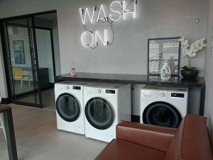 uma lavandaria com duas máquinas de lavar roupa e uma placa que lê lavar em Studio 811 em Marília