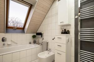 uma casa de banho com um lavatório, uma banheira e uma janela em Apartments Harbour Apartments Höri 50m vom See am Yachthafen Moos bei Radolfzell em Moos