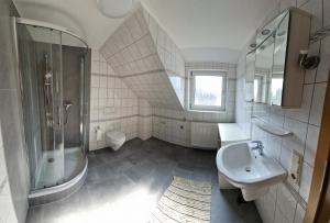 a bathroom with a sink and a shower and a toilet at 2nd home ferienwohnung in Nordenham