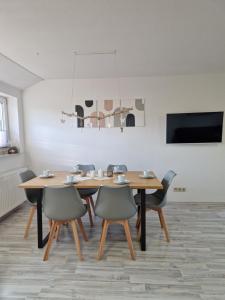 a dining room with a wooden table and chairs at 2nd home ferienwohnung in Nordenham