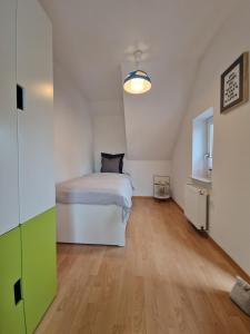 a bedroom with a white bed and a wooden floor at 2nd home ferienwohnung in Nordenham