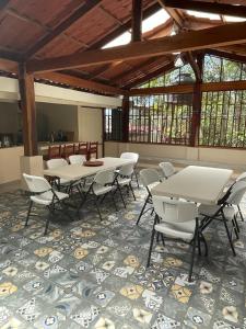 un grupo de mesas y sillas en una habitación en Casa Atardecer Turrubares, 