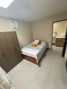 a small bedroom with a bed and a mirror at Casa Atardecer Turrubares 