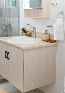 a bathroom with a sink and a shower at Sanel’s Luxury Stay in Discovery Bay