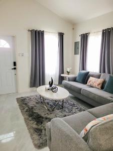 a living room with a couch and a table at Sanel’s Luxury Stay in Discovery Bay