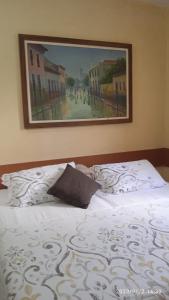 um quarto com uma cama com um quadro na parede em Hospedaria FOR755 em Fortaleza