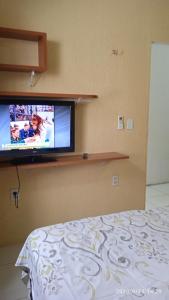 a bedroom with a flat screen tv on a wall at Hospedaria FOR755 in Fortaleza